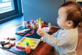 Asian baby playing alone with toy kitchen kit Royalty Free Stock Photo