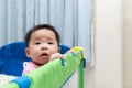 Asian baby in playpen