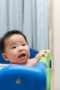 Asian baby in playpen