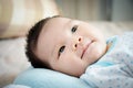 Asian baby portrait. cute Asian baby girl open eyes on the comfortable bed looking for parent on day time with little smile.