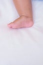 Asian baby`s feet are sleeping on a white bed sheet with copy space Royalty Free Stock Photo