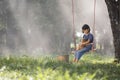 Asian baby on swing with puppy.