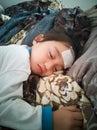 Asian baby toddler getting a fever and sleeping on a comfortable bed