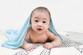 Asian baby under the towel after bathing at home lying on a bed under blue towel,Portrait of a crawling baby Royalty Free Stock Photo