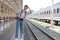 Asian backpack traveler woman with camera standing at train station platform and waiting train arrivel, summer holiday Royalty Free Stock Photo