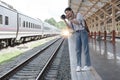 Asian backpack traveler woman with camera standing at train station platform and waiting train arrivel, summer holiday Royalty Free Stock Photo