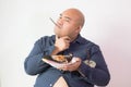 Asian bald fat man with big belly happy in food