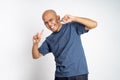 asian bald man laughing with finger gestures pointing cheek