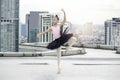Asian ballerina dancer girl practicing ballet dancing on rooftop with skyscraper city view, adorable child dancing in ballet Royalty Free Stock Photo