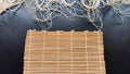 Asian bamboo mat and napkin from yellow bamboo on black surface. Background, texture, frame, copy space, location for Royalty Free Stock Photo