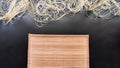 Asian bamboo mat and napkin from yellow bamboo on black surface. Background, texture, frame, copy space, location for Royalty Free Stock Photo