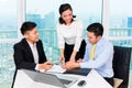 Asian banker counseling man in office