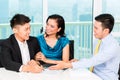 Asian banker selling insurance to couple