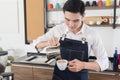 Asian barista man is determined to make coffee for customers, work in coffee shop with happiness Royalty Free Stock Photo