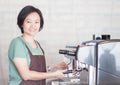 Asian barista smiling and making cup of coffee