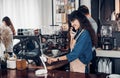 Asian Barista use tablet take order from customer in coffee shop,cafe owner writing drink order at counter bar,Food and drink Royalty Free Stock Photo