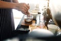 Asian barista young man making coffee according to order at counter bar with natural sunlight in the morning in modern cafe. Royalty Free Stock Photo