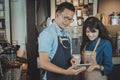 Asian baristas taking an order by digital tablet. Cafe restaurant service, food and drink industry concept.