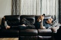 Asian bearded man lay down on couch in living room at home. looking at cell phone