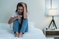 Asian beautiful depression girl crying in tears sit on bed in bedroom. Attractive unhappy young woman feeling sad lonely and upset