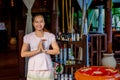 Asian beautiful female spa worker smiling at the spa reception area holding tray with cosmetic product