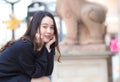 Asian beautiful girl in black long sleeve shirt sits on chair in park outdoor