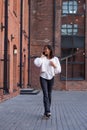 Asian beautiful happy girl walking down the street and talking on mobile phone. Royalty Free Stock Photo