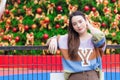 Asian beautiful lady wears colorful sweater and stands in front of Christmas tree in New Year celebrate theme