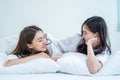 Asian beautiful lesbian couple wake up from sleep in bedroom in morning. Attractive gay girl friend in pajamas look at each other Royalty Free Stock Photo