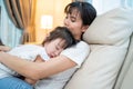 Asian beautiful loving mother hugging sleeping baby girl in her arms. Parent hold small baby to rest on shoulder with gently and Royalty Free Stock Photo