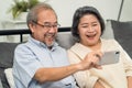 Asian beautiful old woman and senior man couple in love using mobile phone for video call with son, daughter and talking to grandc Royalty Free Stock Photo