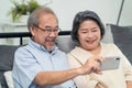 Asian beautiful old woman and senior man couple in love using mobile phone for video call with son, daughter and talking to grandc Royalty Free Stock Photo