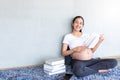 Asian beautiful pregnant woman resting and reading a book while sitting on the floor in living room. Royalty Free Stock Photo