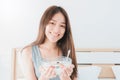 Asian beautiful smiling woman holding a bowl for breakfast is yogurt with fruit in bedroom morning background with vintage tone. Royalty Free Stock Photo