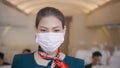 Asian beautiful woman cabin crew is wearing protective mask onboard , taking of face mask and smiling , safe travel , COVID-19