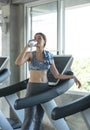 Asian beautiful woman drinking water in bottle after exercise in fitness gym. Concept of slim and healthy girl workout Royalty Free Stock Photo