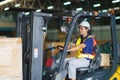 Asian beautiful woman driver drive fork lift car in industry with smile, ability of girl and diversity of career wearing helmet in Royalty Free Stock Photo