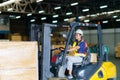 Asian beautiful woman driver drive fork lift car in industry with smile, ability of girl and diversity of career wearing helmet in Royalty Free Stock Photo