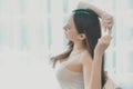 Asian beautiful woman long hair,wearing white shirt,sitting by window with sunlight, looking alluring and sexy, with relax attitud