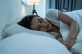 Asian beautiful woman lying down on bed in bedroom, dreaming at night. Attractive young female in pajamas sleeping alone on Royalty Free Stock Photo