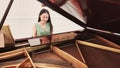 Asian beautiful woman is playing and practice piano as hobby for music therapy with happiness