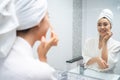 Asian beautiful woman putting smooth and skin care for facial soft. Attractive female touches on face and applying cream lotion Royalty Free Stock Photo