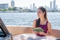 Asian beautiful woman reading book while traveling and sitting on boat with background of beautiful lanscape. Summer Travel and Royalty Free Stock Photo