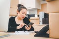 Asian beautiful woman Receiving order by phone and notebooks in selling products online Royalty Free Stock Photo