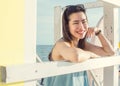 Asian woman smiling and sitting beside the beach