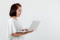 Asian beautiful woman Standing in a white shirt in her hand Holding a laptop computer Stand smiling happily With a white Royalty Free Stock Photo