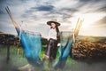 Asian Beautiful woman in Thai local dress standing and working with fishing net in fishing village with field and lake Royalty Free Stock Photo