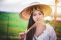 Asian Beautiful woman in Thai local dress working with fishing net in fishing village with field and lake background Royalty Free Stock Photo