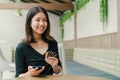 Asian beautiful woman Wearing a black shirt Sitting in the house There is a credit card in your hand and you are holding the phone