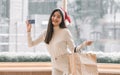 Asian woman wearing santa hat, holding credit card and paper bags Royalty Free Stock Photo